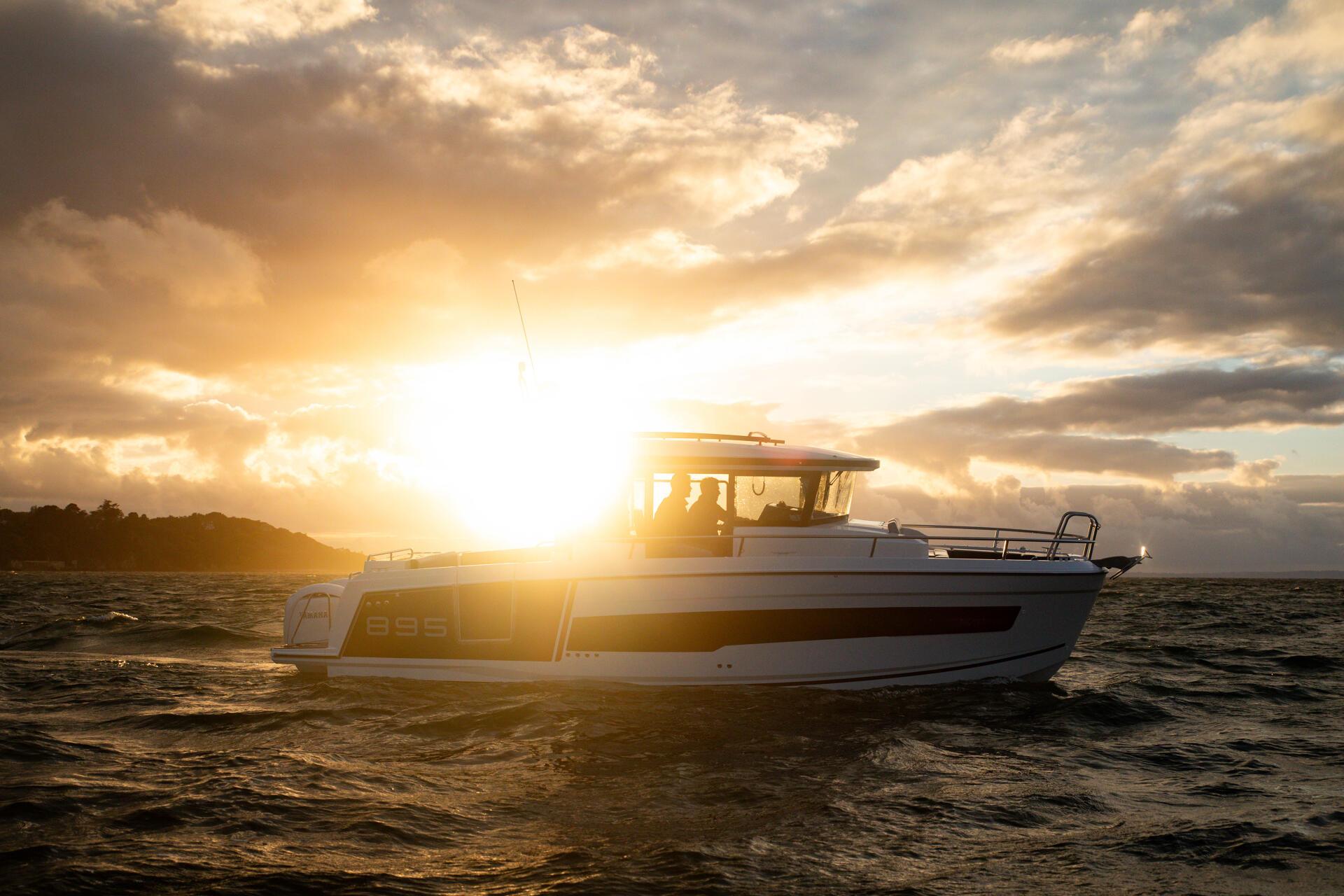 a boat Merry fisher 895 S2 on the water with the sunset in the background