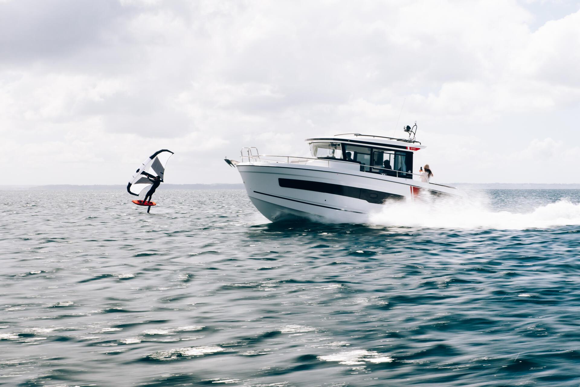 a boat with a boat Merry fisher 895 S2 with a kite surfing in the water